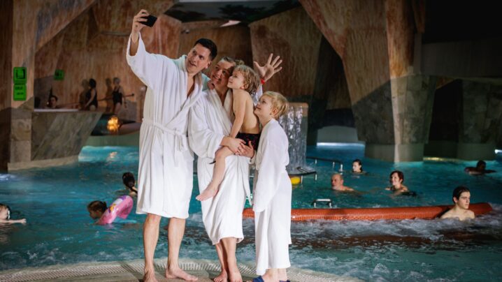 A family in white bathrobes taking a picture of themselves in the Viking Saga water and sauna center.
