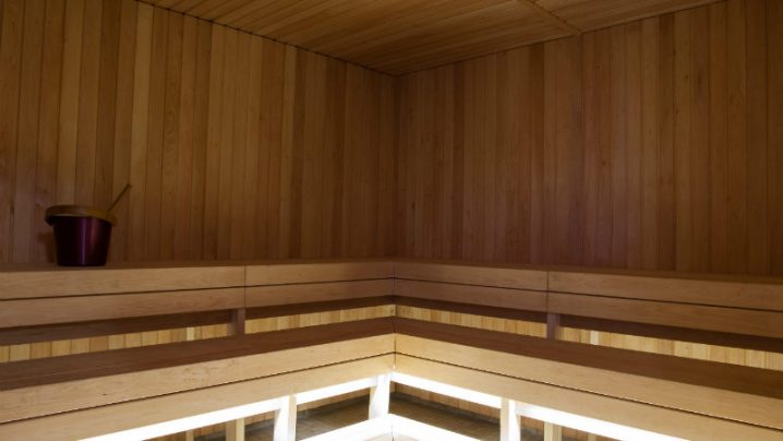 A picture of a sauna with lighting shining from under the benches