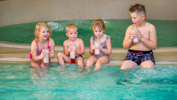 Children sitting by the pool and enjoying ice cream cocktails